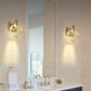 Bathroom with gold wall sconces and a large mirror.