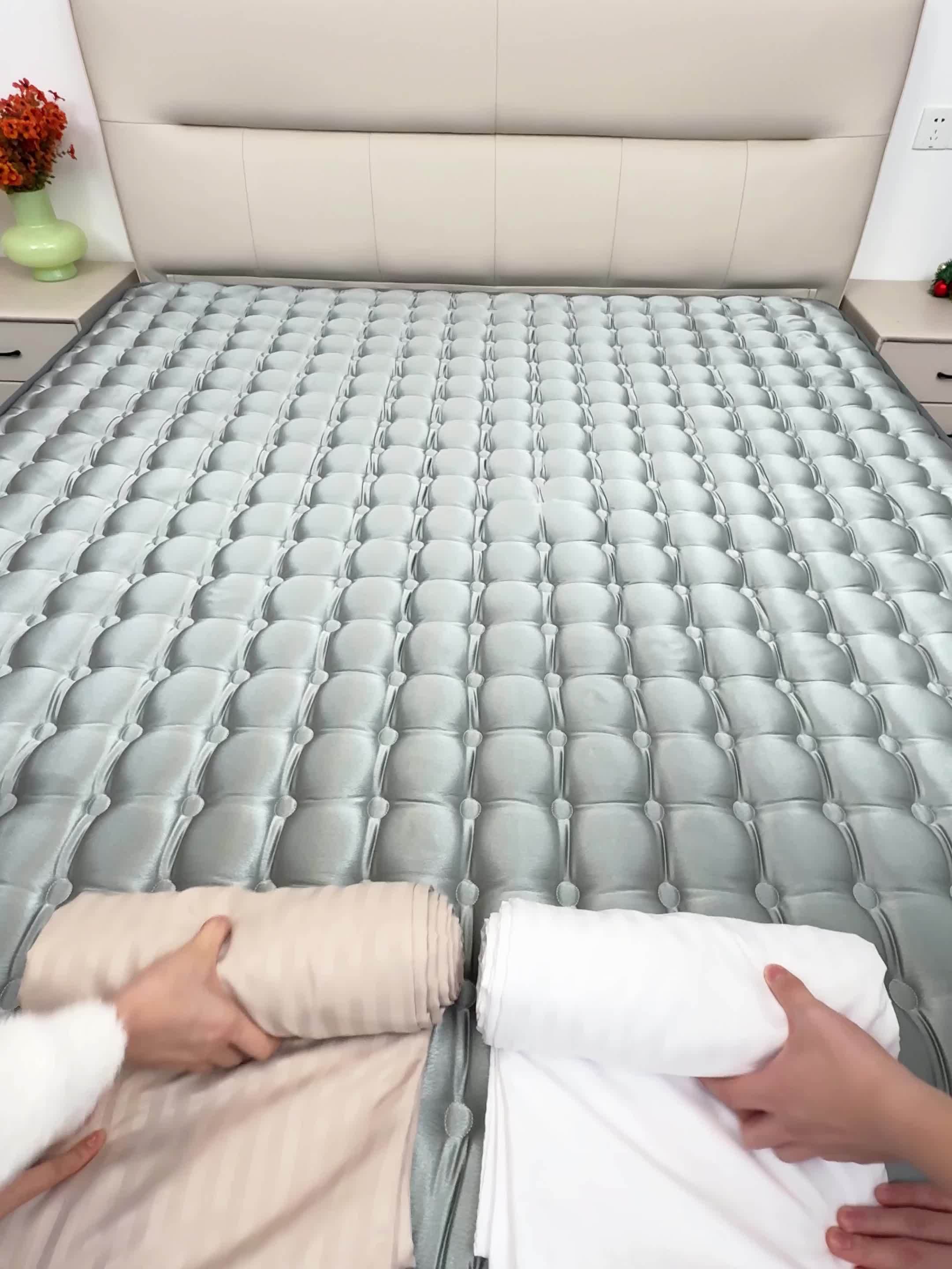 Person unrolling a mattress on a bed