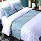 Bed with white bedding and blue decorative runner in a bedroom setting.